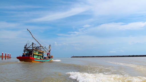 A seascape view of a fisherman fishing boat heading towards an open ocean for fishing over a blue bright sky and a cloudy day. Image shoot from a boat at Kuala Besut Jetty, Terangganu, Malaysia