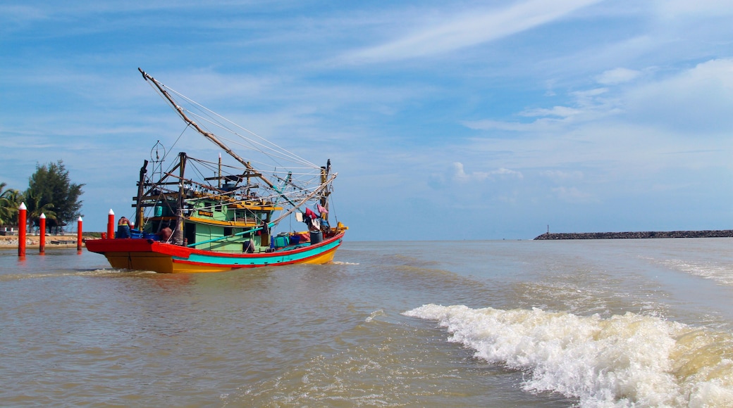 A seascape view of a fisherman fishing boat heading towards an open ocean for fishing over a blue bright sky and a cloudy day. Image shoot from a boat at Kuala Besut Jetty, Terangganu, Malaysia