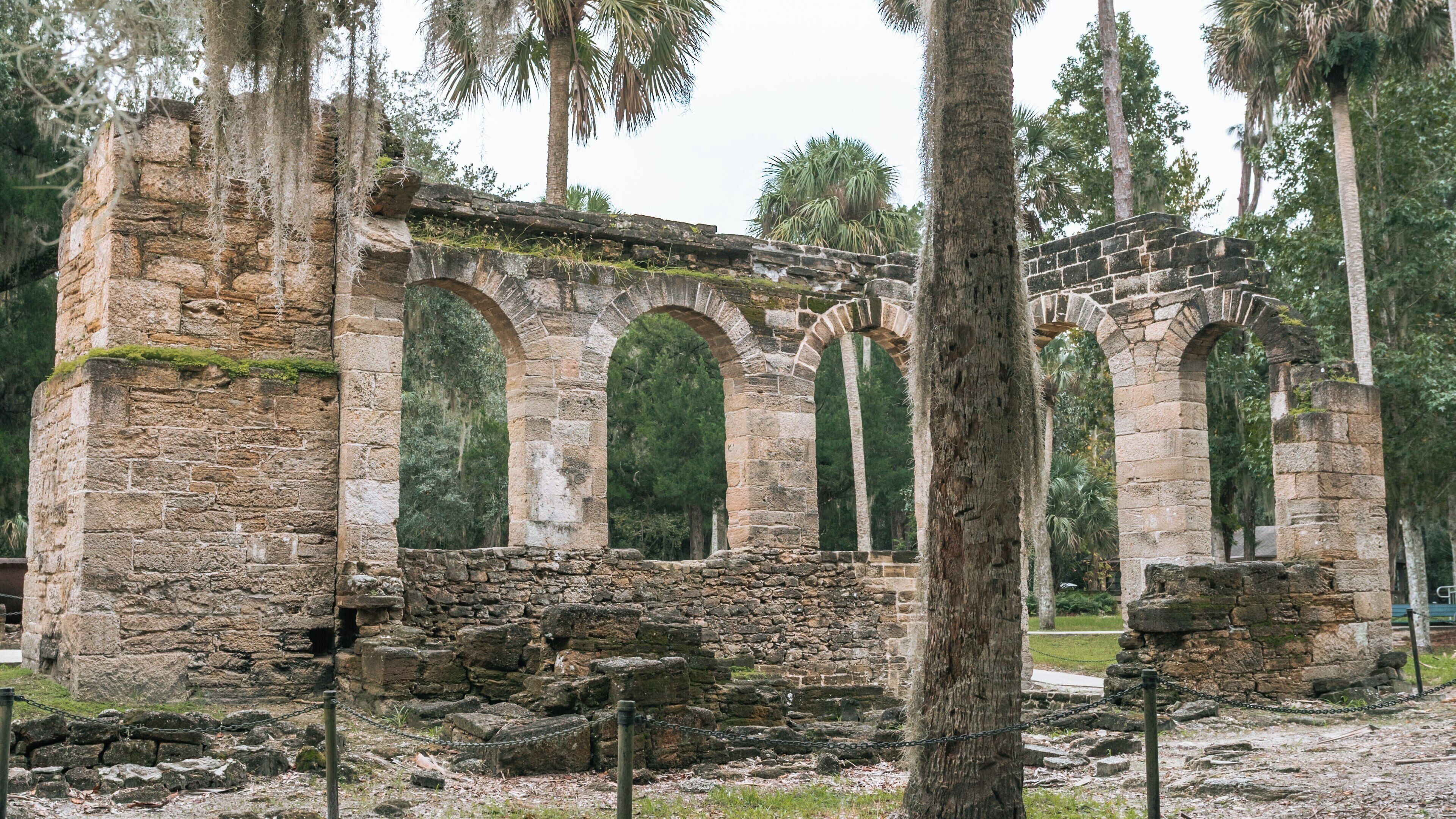 Exploring the Historic Sugar Mill Ruins in New Smyrna Beach, Florida with Lush Surroundings and Palm Trees