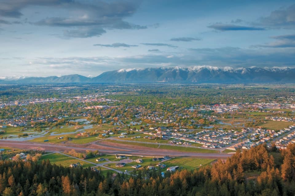 Een stad omringd door bergen en bossen.
