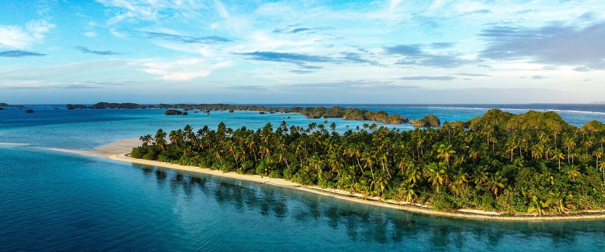 A panorama of a beautiful palm lined beach ion Lau group Fiji shot from a drone.
