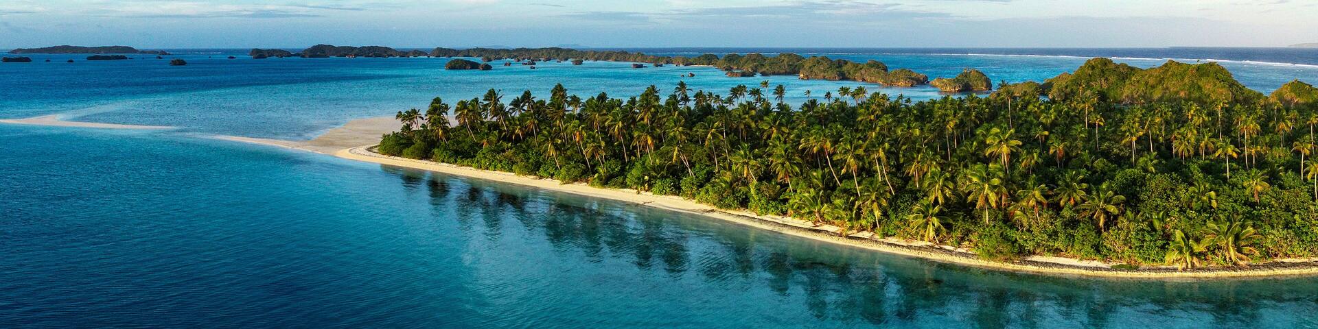 A panorama of a beautiful palm lined beach ion Lau group Fiji shot from a drone.