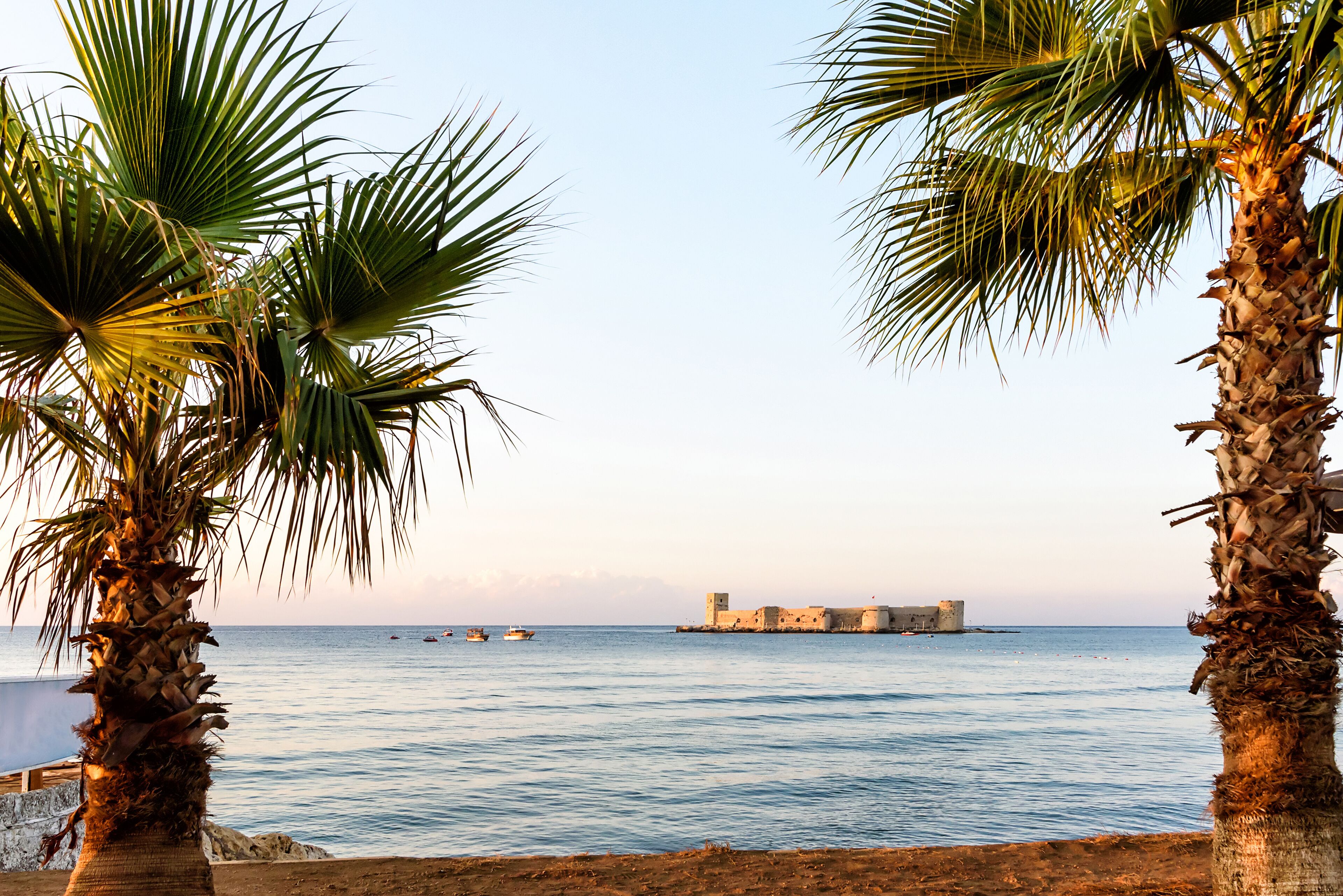 Mersin, Turkey - August 16, 2019: Maiden's castle, Kiz Kalesi with palm in Mediterranean Sea. Mersin Turkey