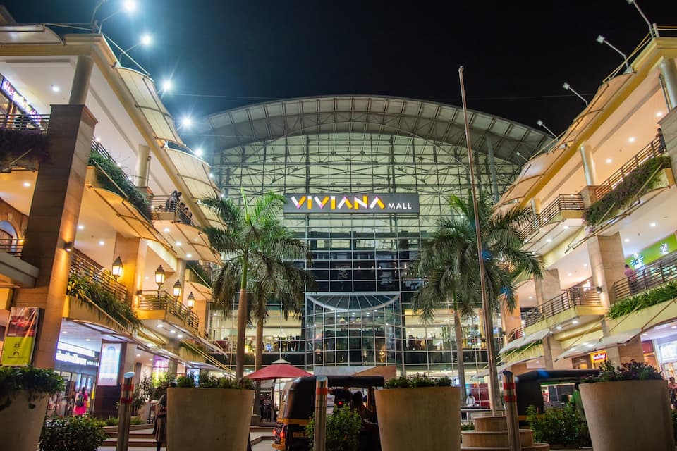 A Viviana Mall with a glass facade, palm trees, and multiple levels of shops and restaurants.