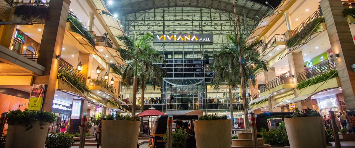 A Viviana Mall with a glass facade, palm trees, and multiple levels of shops and restaurants.