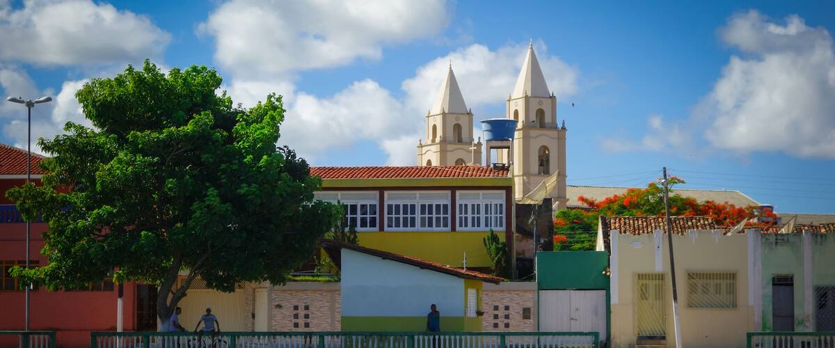 A boat docked near a colorful building with a church in the background.