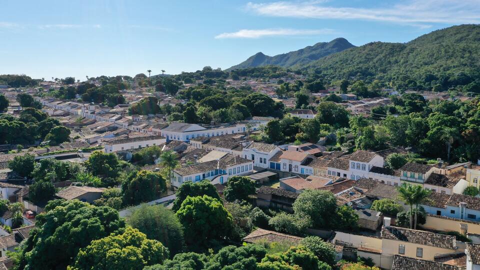 A town with white buildings and green hills in the background.