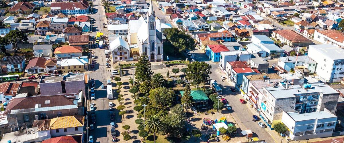 A densely packed town with a prominent church and a central square with palm trees.