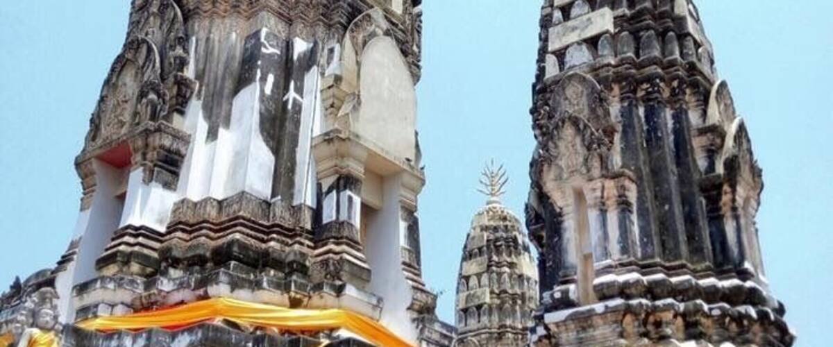 A temple with tiered, ornate structures and a brick base.