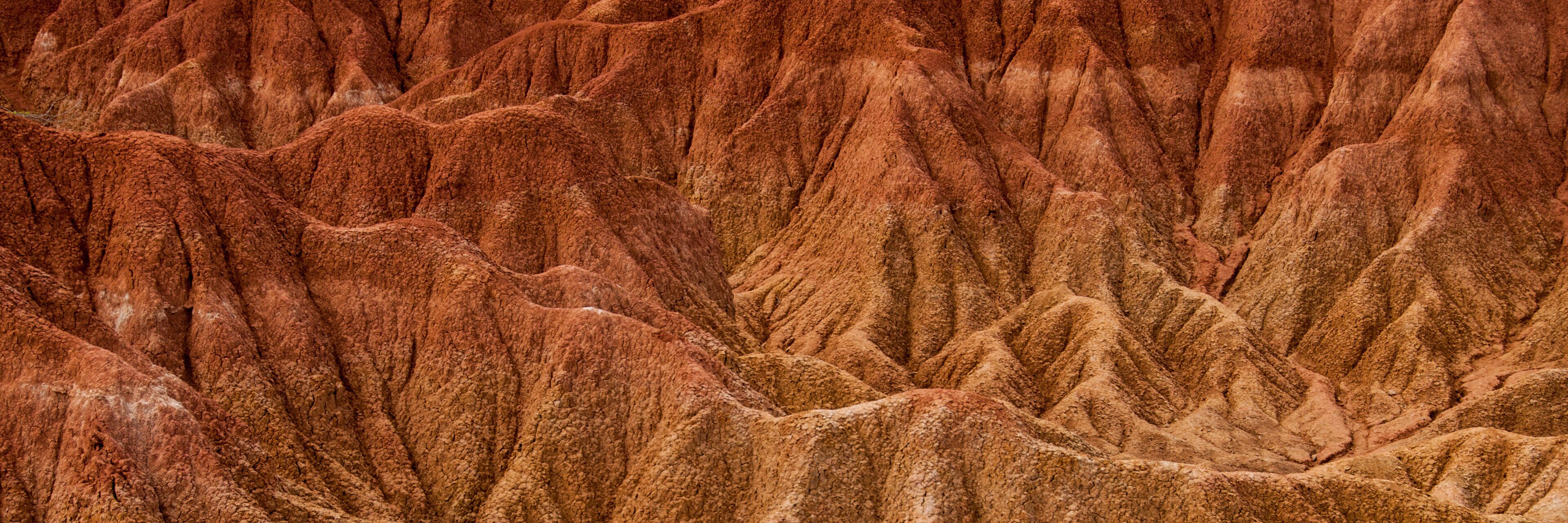A rugged, textured landscape with steep, rocky formations.