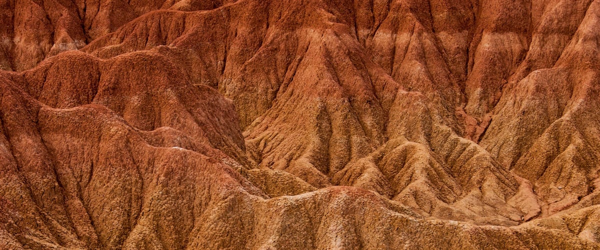 A rugged, textured landscape with steep, rocky formations.