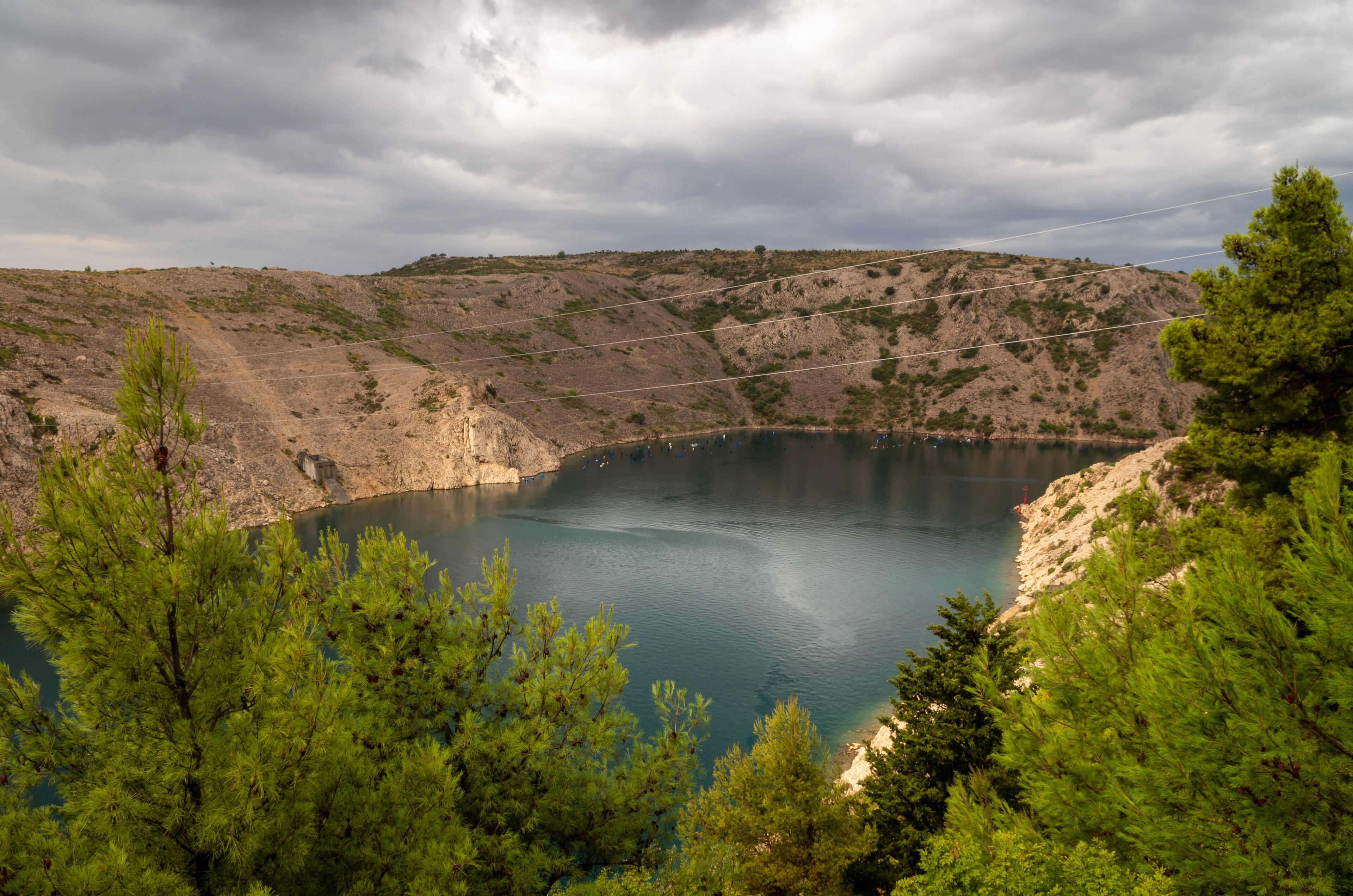 A lake surrounded by rocky hills and pine trees.