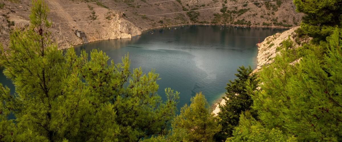 A lake surrounded by rocky hills and pine trees.