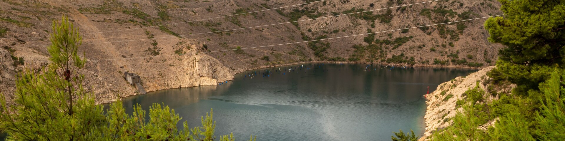 A lake surrounded by rocky hills and pine trees.