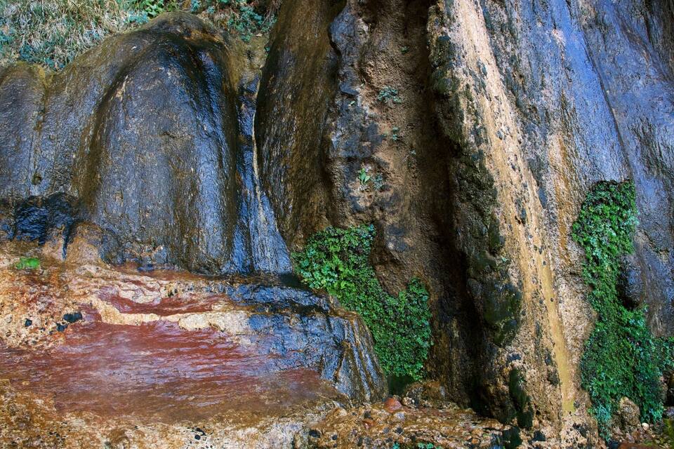 Paisagem rochosa com grandes pedras e uma pequena massa de água.