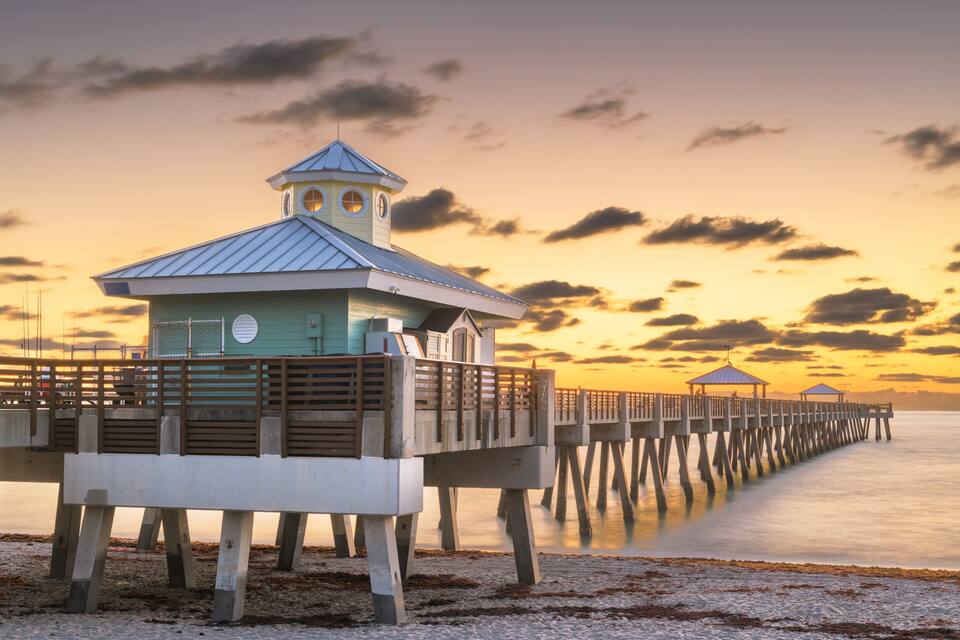 A pier extending into the water with a lighthouse and a gazebo.