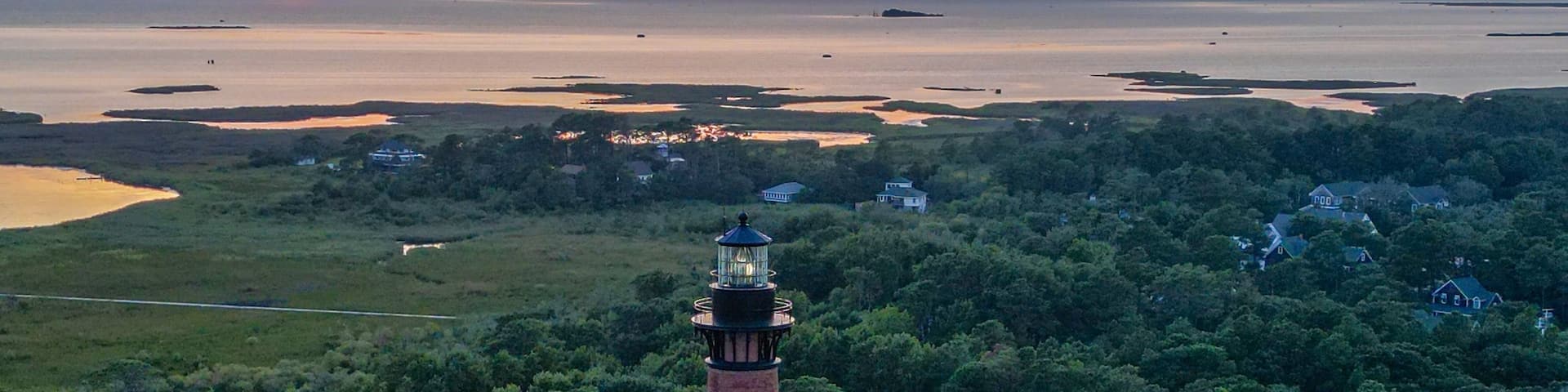 Aerial view of Currituck Beach Lighthouse on an island surrounded by lush green trees
