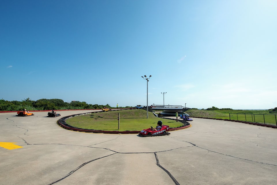 A go-kart track with a clear sky and green surroundings.