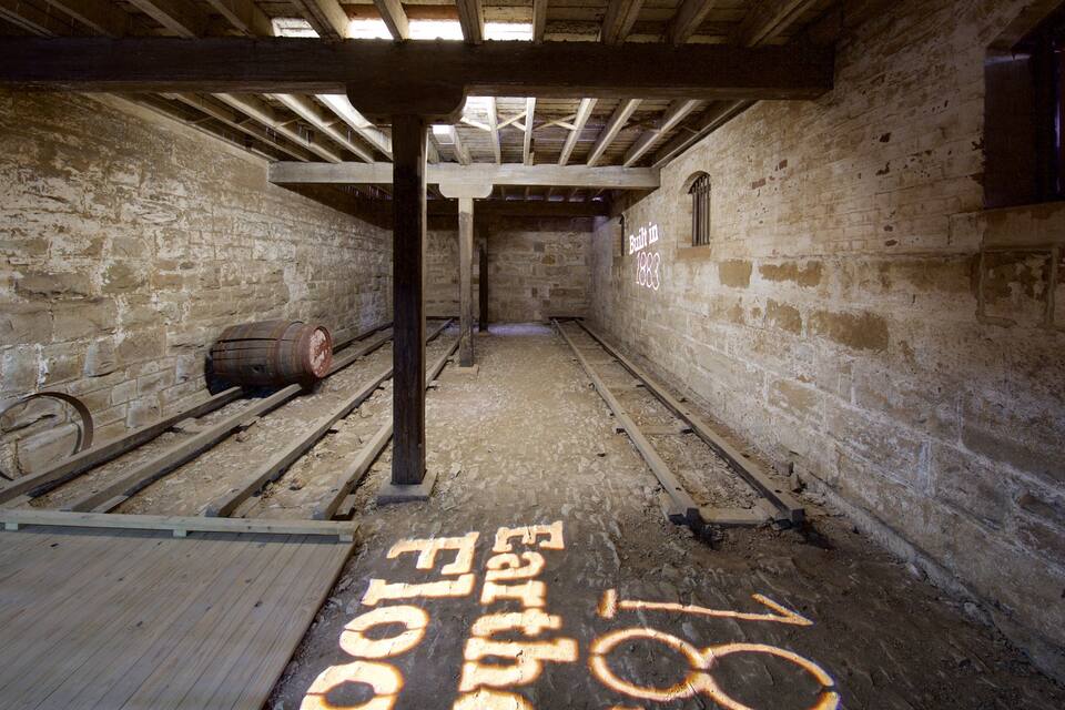 An abandoned building with exposed brick walls, wooden beams, and a wooden platform.