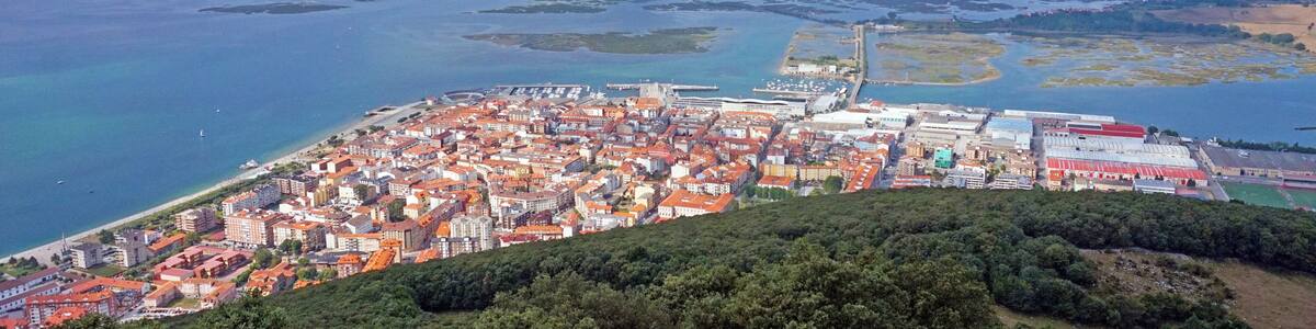 Eine Küstenstadt mit einem markanten Berg, einer Bucht und einer weiten Wasserfläche.