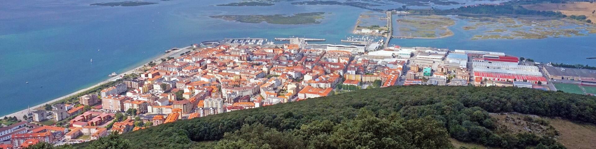 A coastal city with a prominent mountain, a bay, and a large body of water.