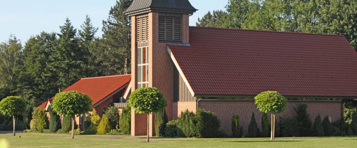 A church with a red roof and a steeple.