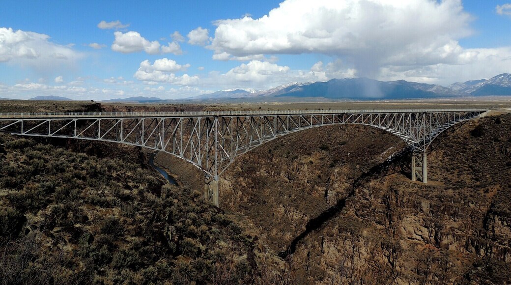 New Mexico certainly has a lot to offer when it comes to scenic wonders, among the best this stunning man-made wonder, the Rio Grande Gorge Bridge.
This National Historic Landmark, part of east-west US Route 64, is one of the most visited tourist attractions in the Taos area.
Parking is available on the west side of the gorge. Be sure to walk out to the cantilevered platforms on either side of the bridge (if heights are not an issue) for the best views. The adjacent state park also offers some great views of the bridge itself. No fees are associated with the bridge or state park.