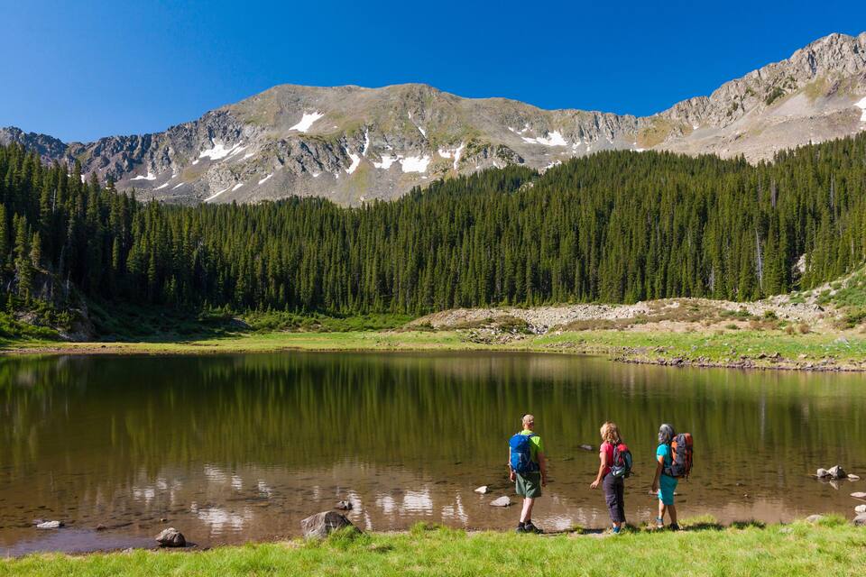 A lake surrounded by mountains and dense forest.