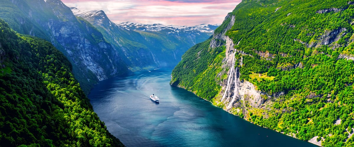 A river winding through a mountainous landscape with dense green forests and steep cliffs.