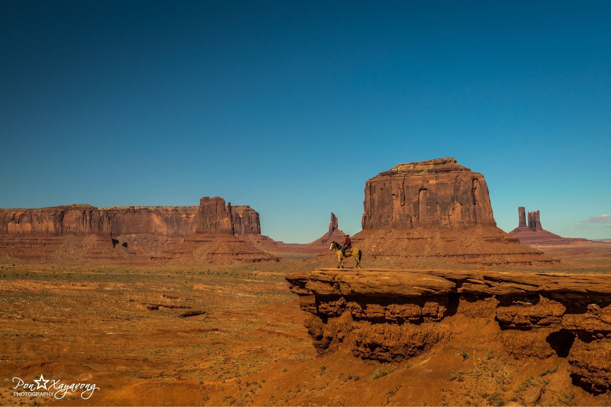 Monument Valley, a red-sand desert region on the Arizona-Utah border, is known for the towering sandstone buttes of Monument Valley Navajo Tribal Park. The park, frequently a filming location for Western movies, is accessed by the looping, 17-mile Valley Drive. The famous, steeply sloped Mittens buttes can be viewed from the road or from overlooks like John Ford’s Point.