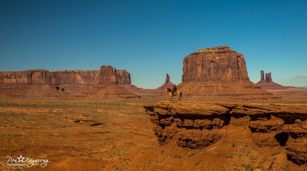 Monument Valley, a red-sand desert region on the Arizona-Utah border, is known for the towering sandstone buttes of Monument Valley Navajo Tribal Park. The park, frequently a filming location for Western movies, is accessed by the looping, 17-mile Valley Drive. The famous, steeply sloped Mittens buttes can be viewed from the road or from overlooks like John Ford’s Point.