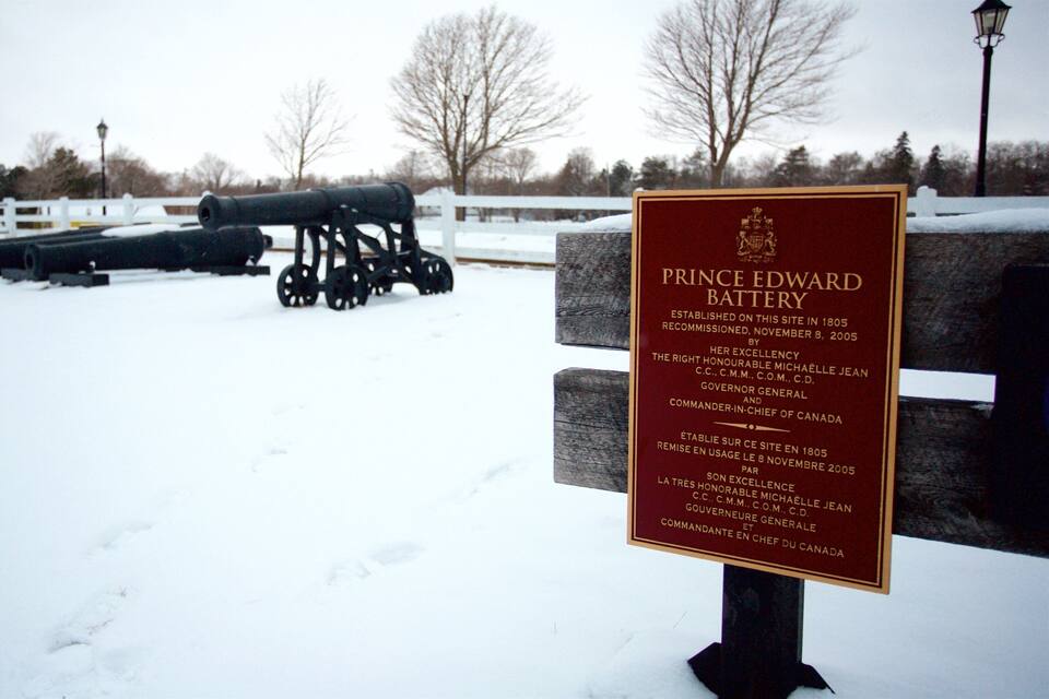 A snow-covered landscape with a cannon and a plaque reading "Prince Edward Battery".