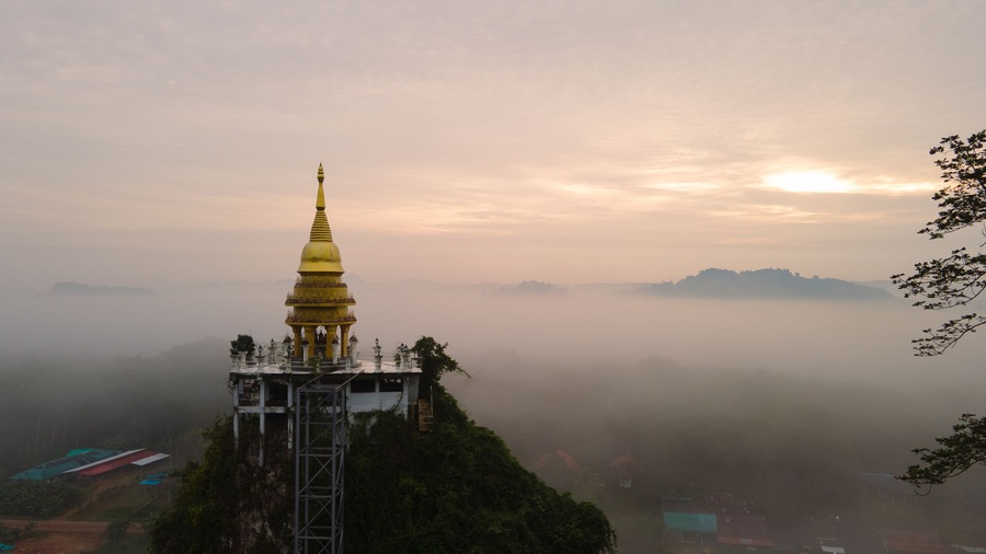 View of Buddhism temple Thamma Park padoga on hill at sunrise in Ban Khao Na Nai village in Phanom, Surat Thani, Thailand