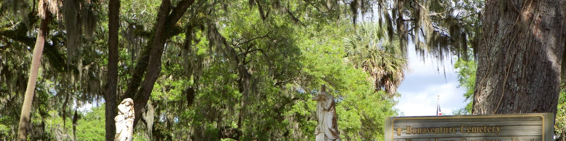 A park entrance with a sign indicating directions to Bonaventure Cemetery, Forest Lawn Cemetery, and Greenwich Cemetery.