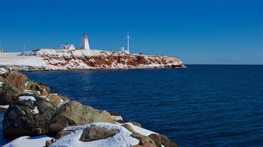Souris Lighthouse which includes snow and a sandy beach
