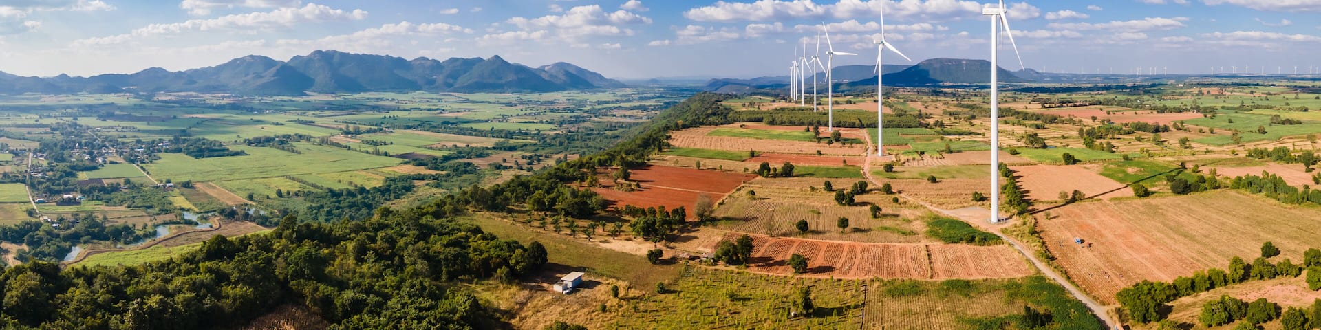 Panorama landscape of Wind turbine arranged in a row on a mountain with blue sky background in Sikhio District, Nakhon Ratchasima, Thailand