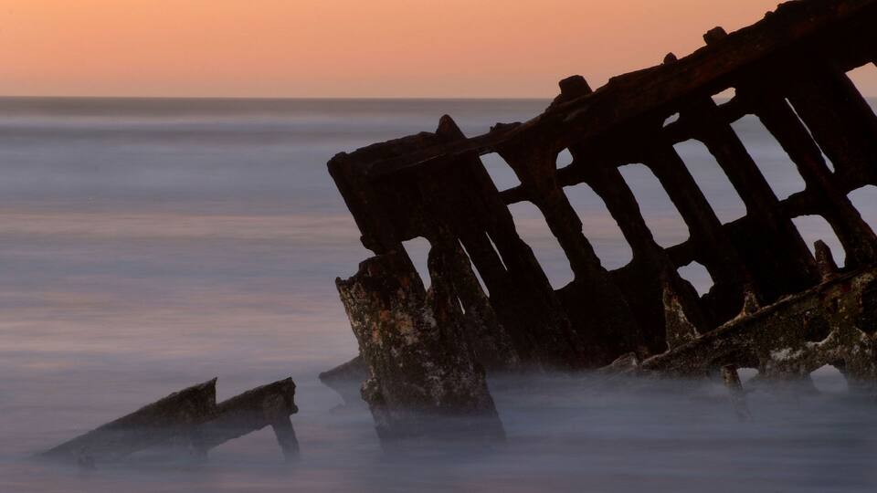 A sunken shipwreck at sunset.