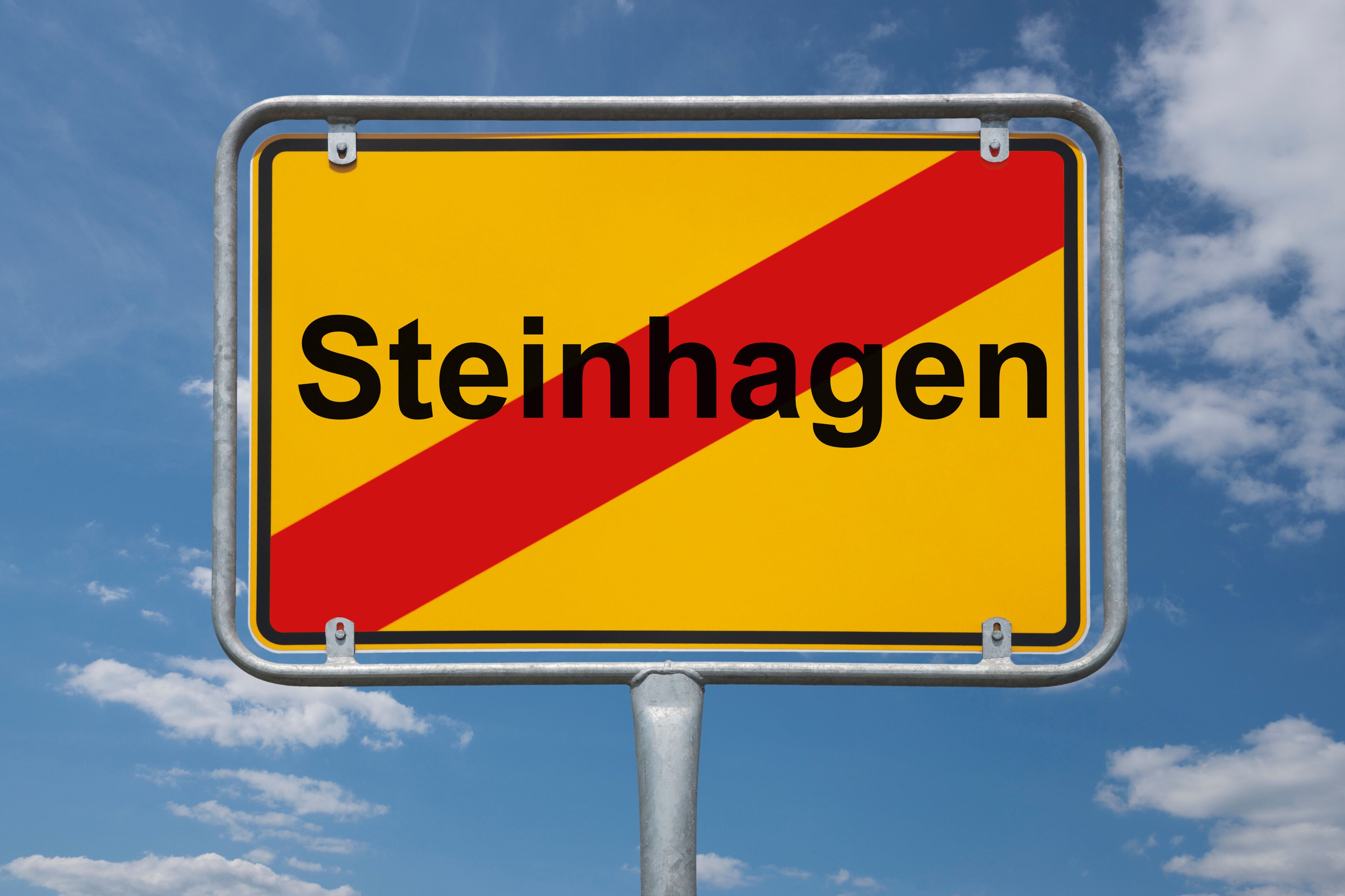 A road sign with the word "Steinhagen" on a yellow background with a red diagonal stripe.