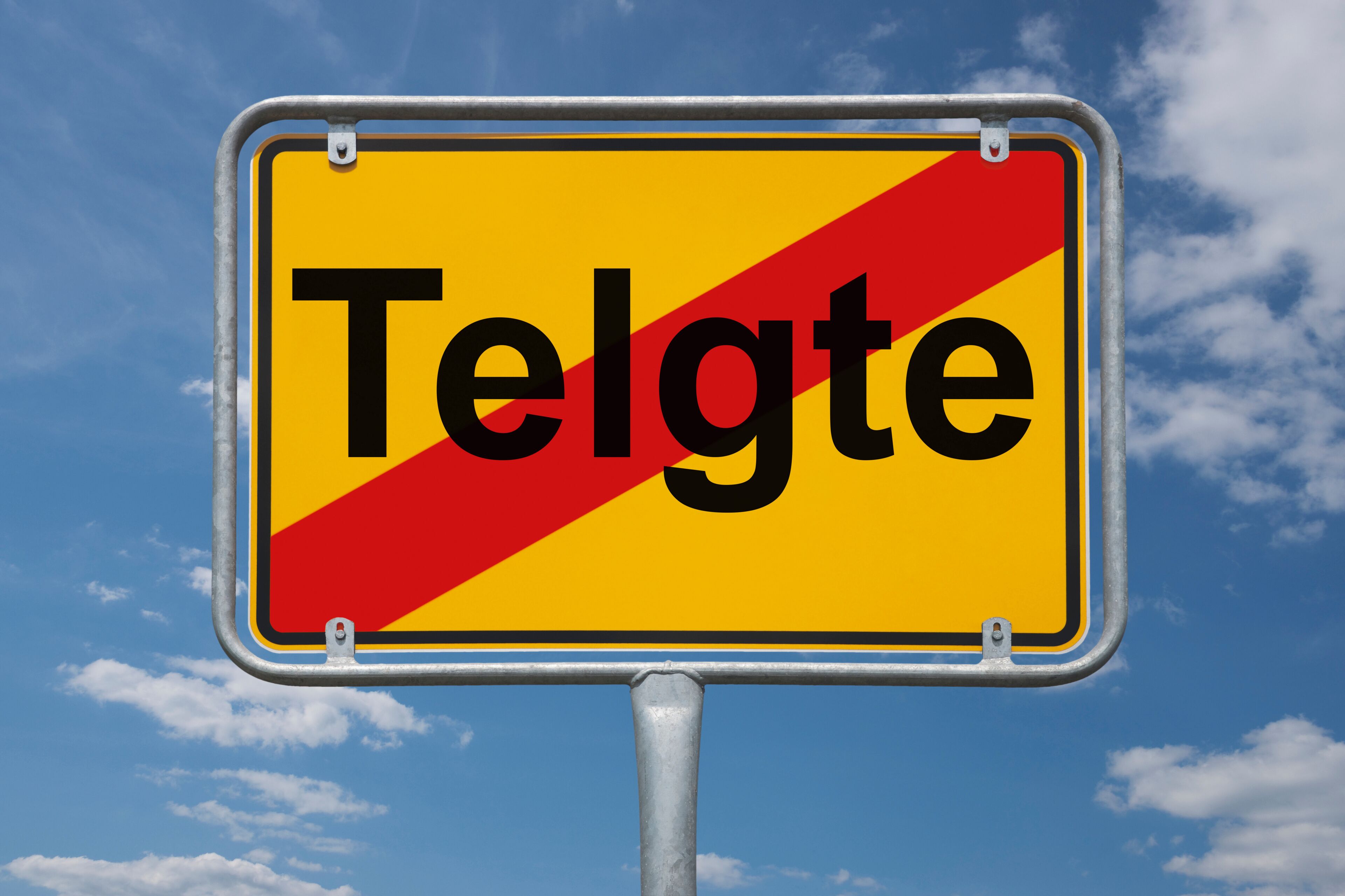 A road sign with the word "Telgte" against a blue sky with clouds.