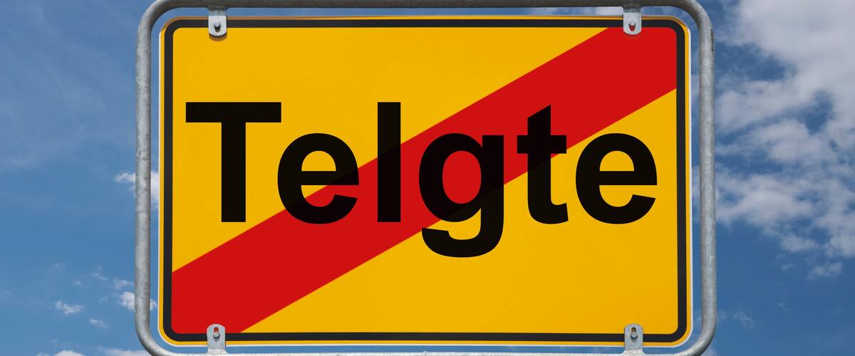 A road sign with the word "Telgte" against a blue sky with clouds.