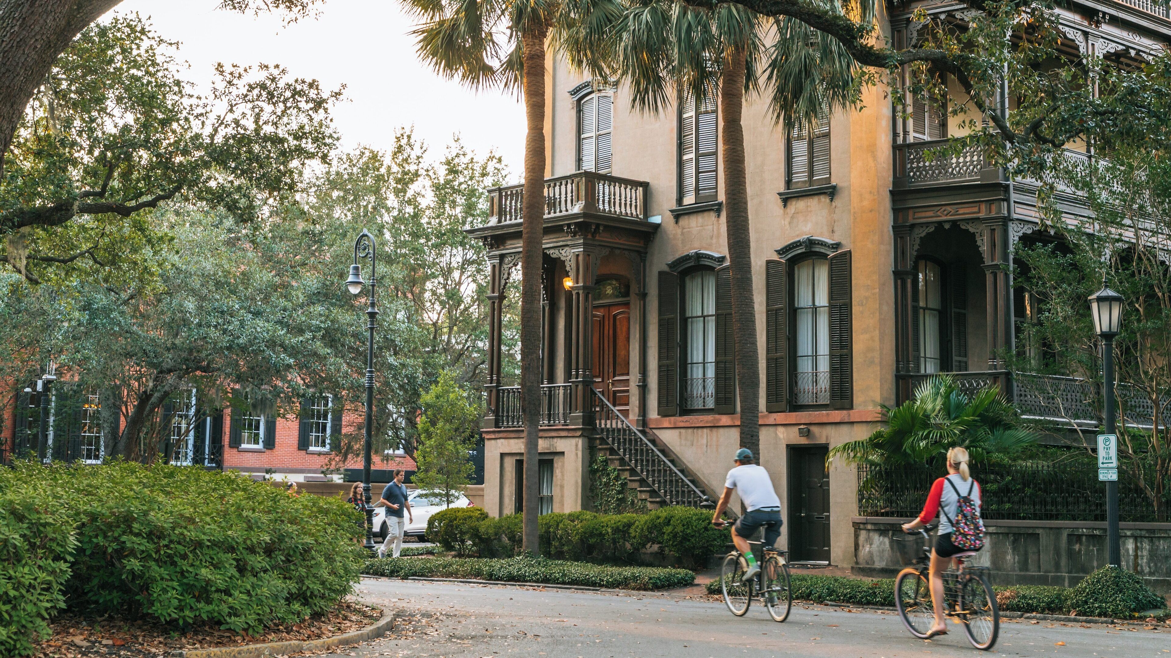 Cyclists enjoy a leisurely ride through Monterey Square in Historic Downtown Savannah, capturing the essence of southern charm