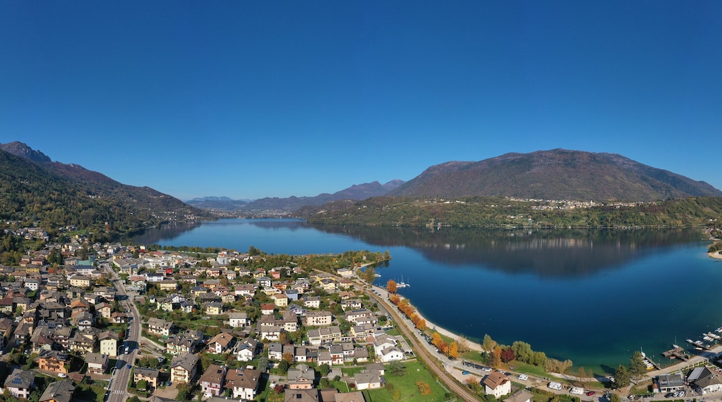 Aerial view of Lake Caldonazzo north of Italy. In the background the trees, Alps, blue sky. Reflection of mountains in water. Autumn season. Multi-colored palette of colors