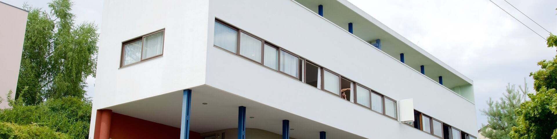 Un edificio moderno blanco con detalles azules y un cartel que dice 'Weissenhof Museum'.