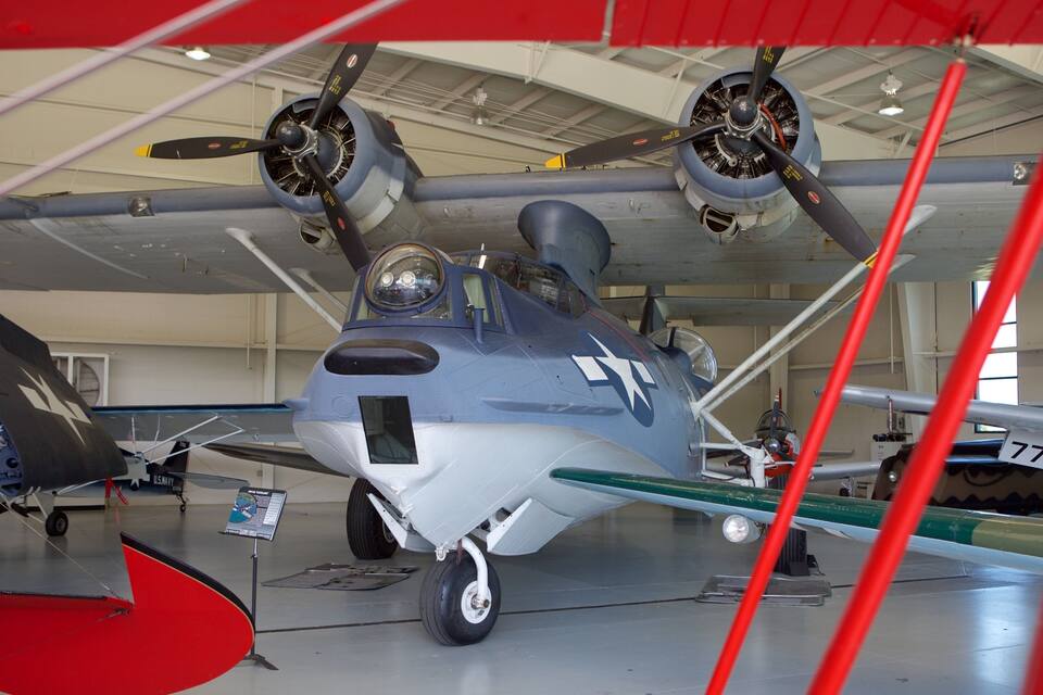 Un avión militar antiguo con hélices, un emblema con una estrella y el número 77 en su fuselaje.
