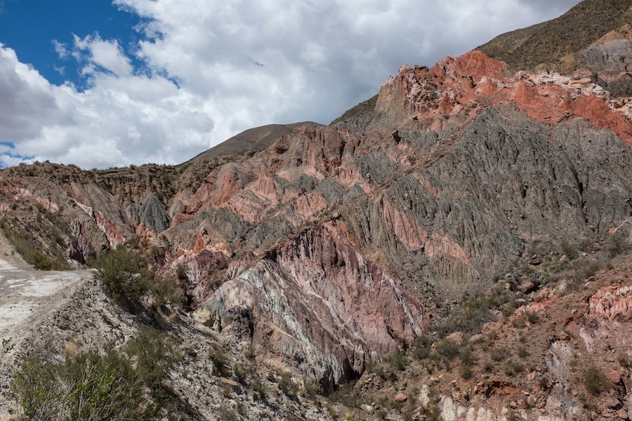 Un paysage montagneux accidenté, caractérisé par des formations rocheuses aux teintes rouge-brun et une végétation clairsemée.