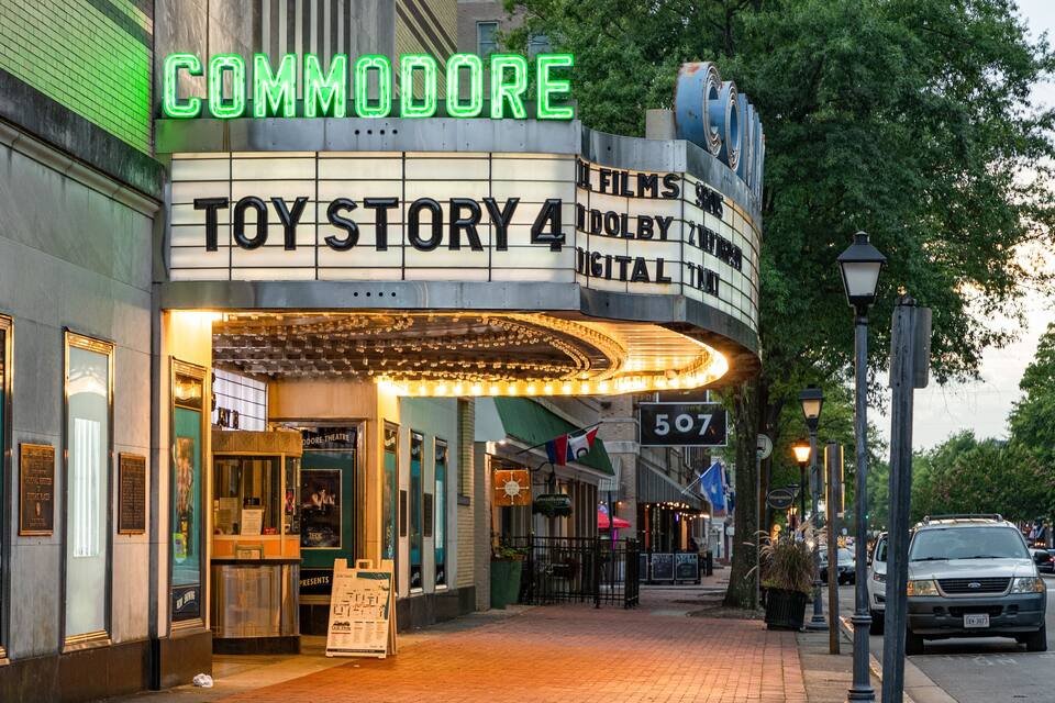 A theater with neon signs and a brick facade.