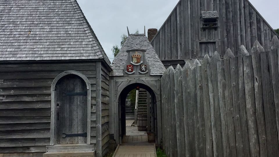 A wooden building with a stone pathway leading to an arched entrance.