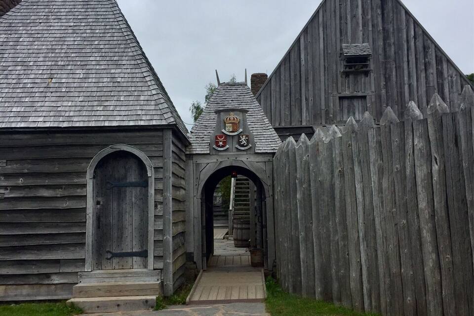 A wooden building with a stone pathway leading to an arched entrance.