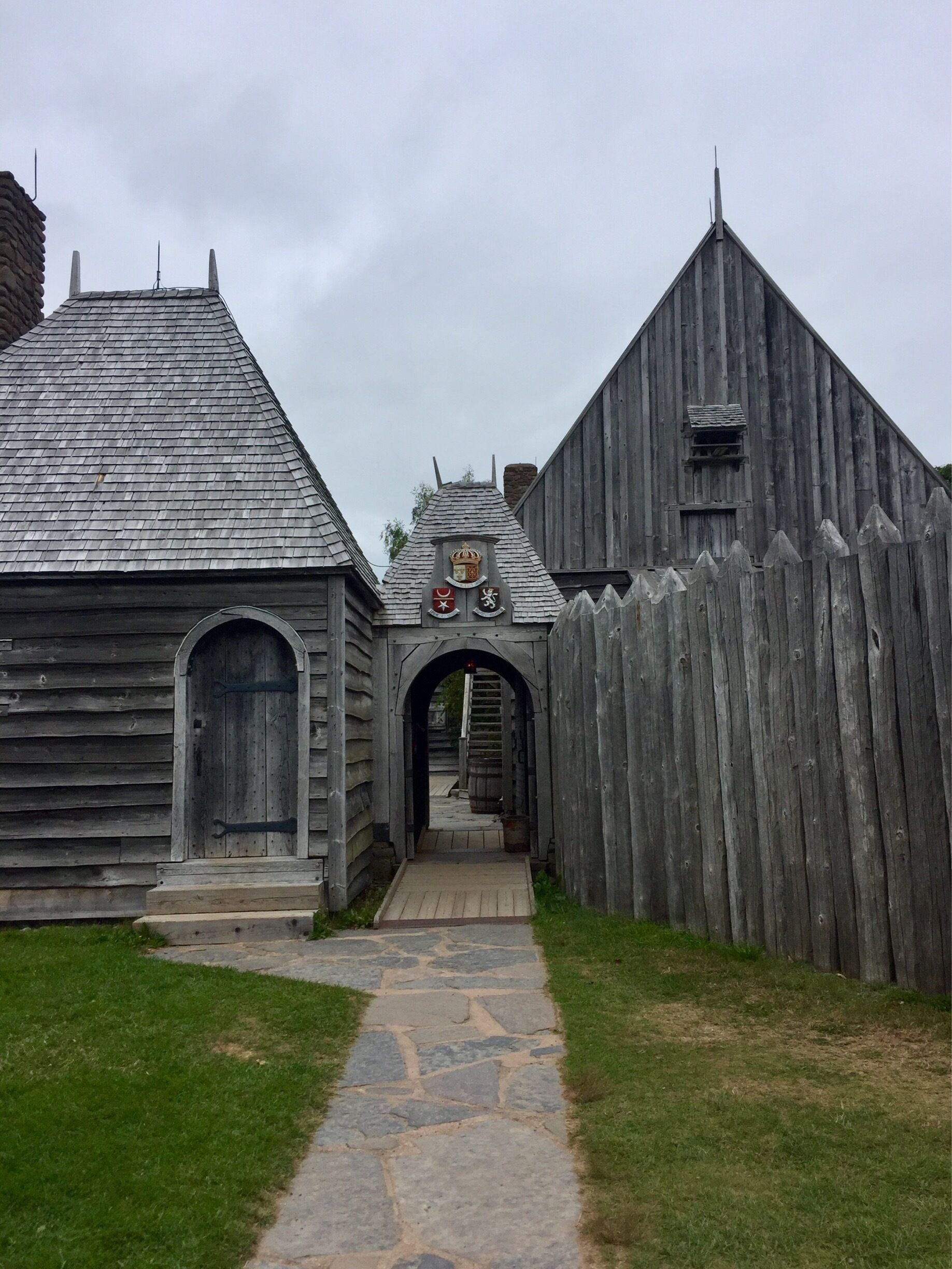 A wooden building with a stone pathway leading to an arched entrance.