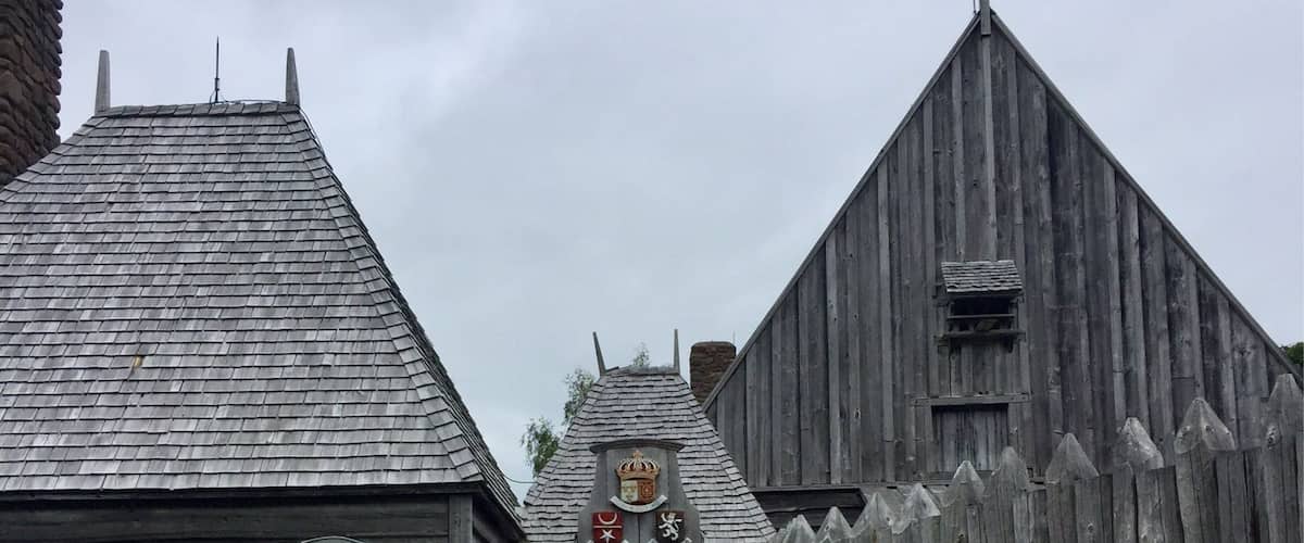 A wooden building with a stone pathway leading to an arched entrance.